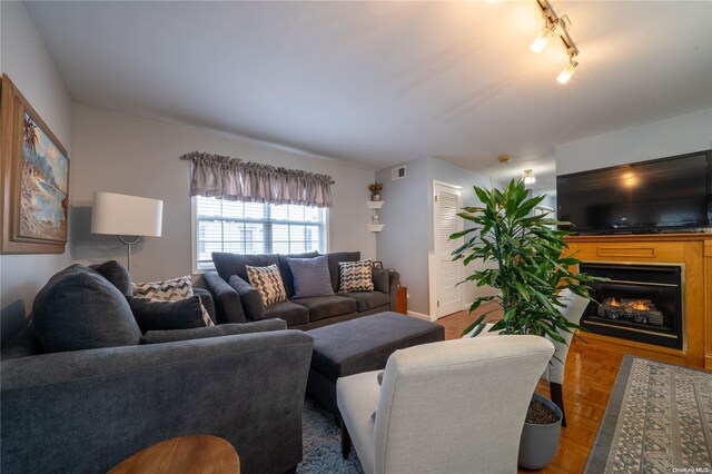 living room with parquet flooring and track lighting