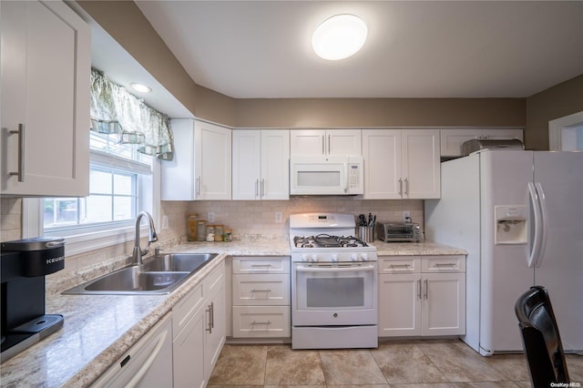 kitchen with decorative backsplash, sink, white cabinets, and white appliances