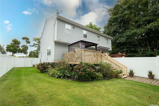 rear view of house with a lawn and a deck