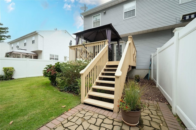 property entrance with a wooden deck and a yard