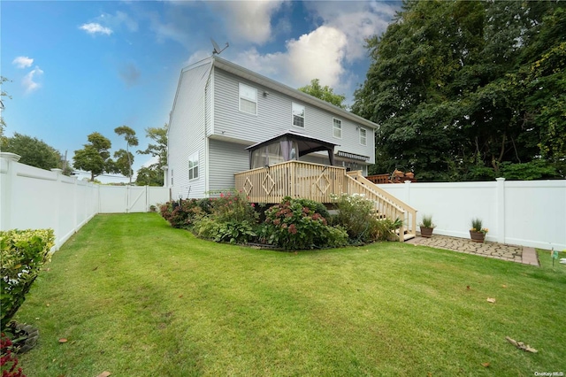 rear view of property with a yard and a deck