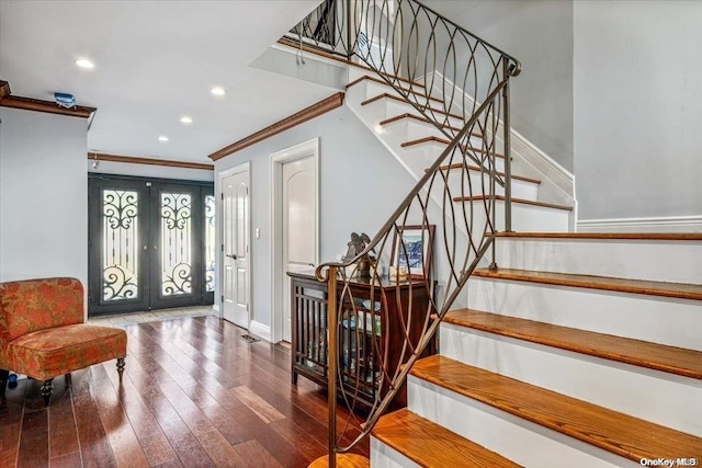 foyer entrance featuring french doors, dark hardwood / wood-style flooring, and ornamental molding