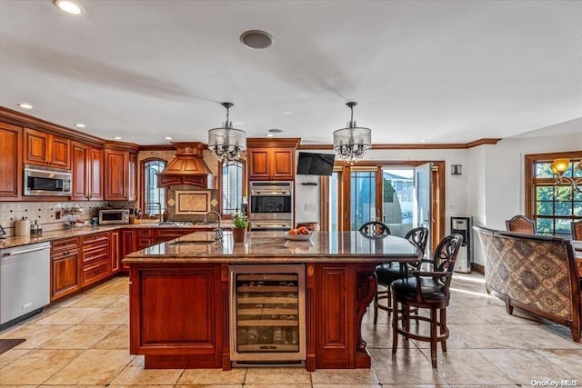 kitchen with appliances with stainless steel finishes, backsplash, a spacious island, decorative light fixtures, and wine cooler