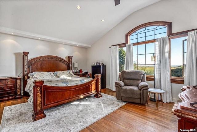 bedroom with ceiling fan, high vaulted ceiling, and light hardwood / wood-style flooring