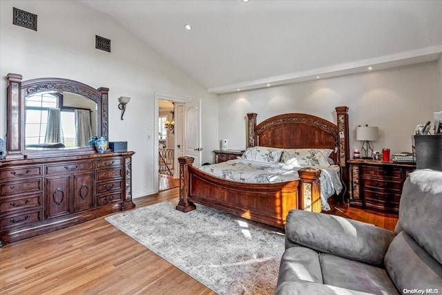 bedroom with high vaulted ceiling and light hardwood / wood-style floors