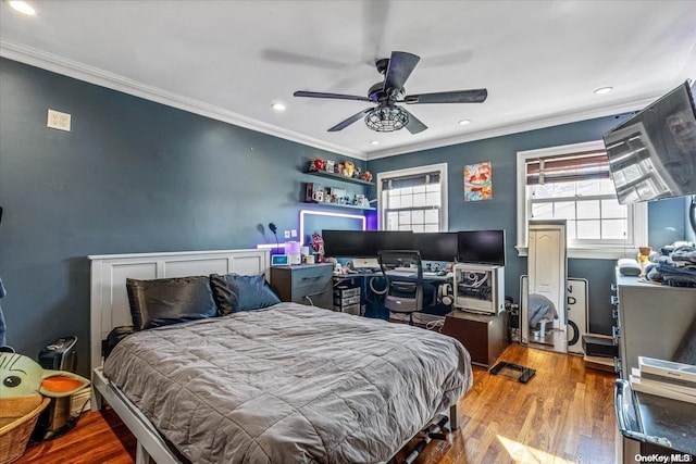 bedroom with hardwood / wood-style floors, ceiling fan, and crown molding