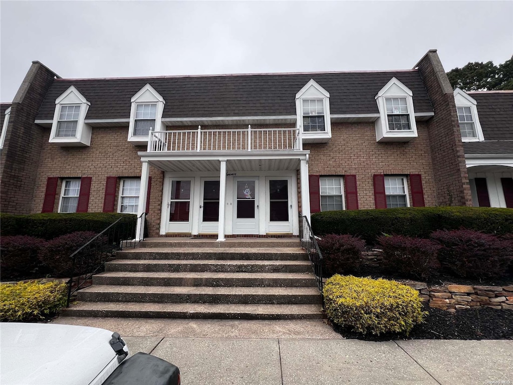 view of front of property featuring a porch and a balcony