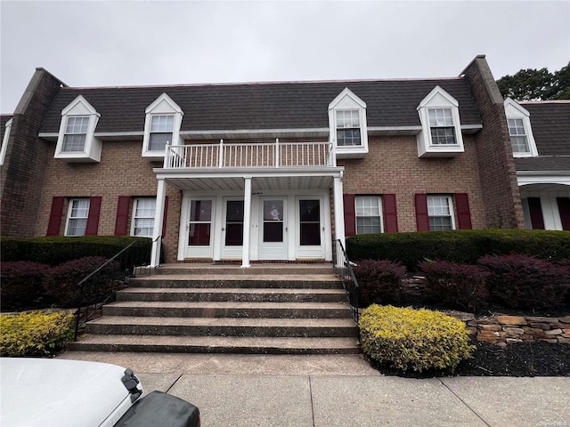 view of front of property featuring a porch and a balcony