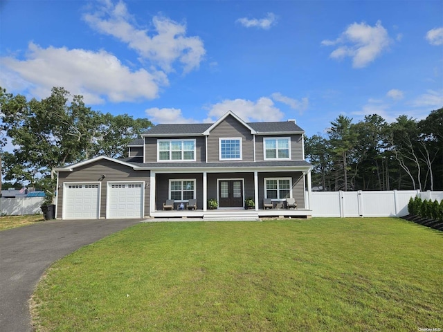 view of front of home with a front lawn, covered porch, and a garage