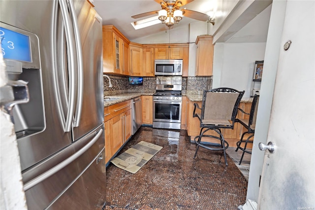 kitchen with decorative backsplash, appliances with stainless steel finishes, light stone counters, sink, and lofted ceiling