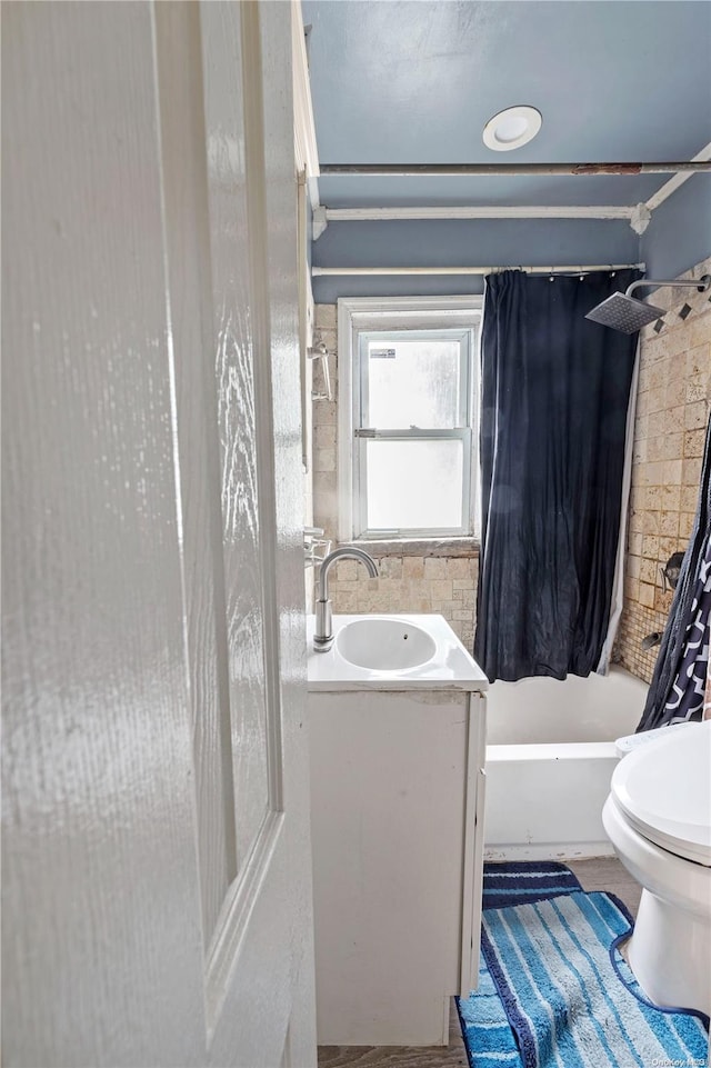 full bathroom with hardwood / wood-style floors, vanity, toilet, and shower / tub combo with curtain