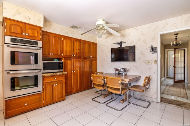 kitchen with light tile patterned floors, ceiling fan with notable chandelier, and appliances with stainless steel finishes