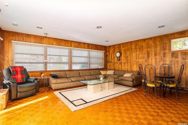 living room with wood walls and parquet floors