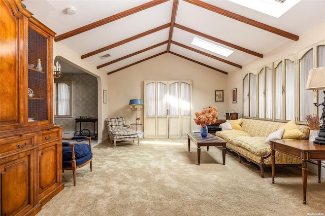 living room with vaulted ceiling with beams and light colored carpet