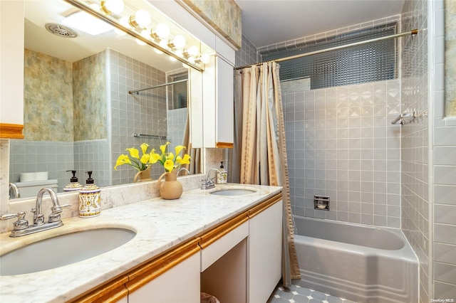 bathroom with shower / bath combo with shower curtain, vanity, and tile walls