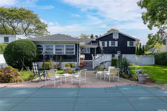 rear view of house featuring a patio area, a sunroom, and a covered pool