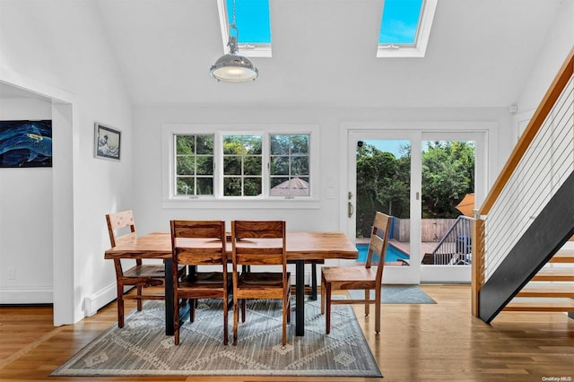 dining room with plenty of natural light, hardwood / wood-style floors, and lofted ceiling