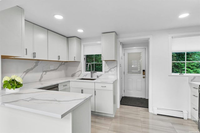 kitchen with kitchen peninsula, decorative backsplash, sink, a baseboard radiator, and white cabinetry