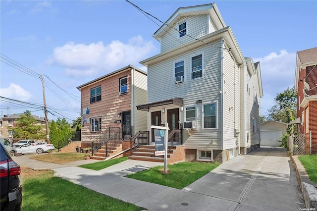 view of front of house with a garage, cooling unit, and an outdoor structure