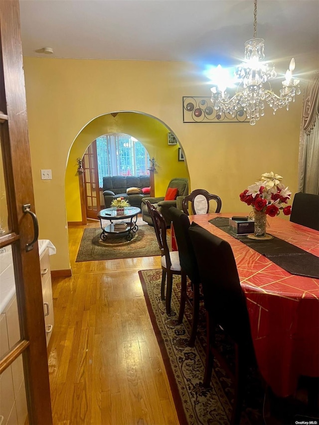 dining room with hardwood / wood-style flooring and an inviting chandelier