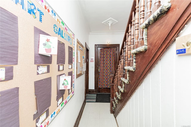 interior space featuring light tile patterned flooring and ornamental molding