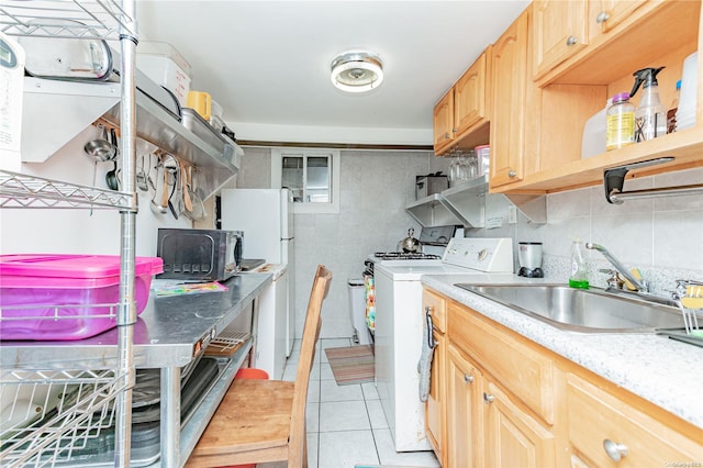 laundry area featuring light tile patterned flooring and sink