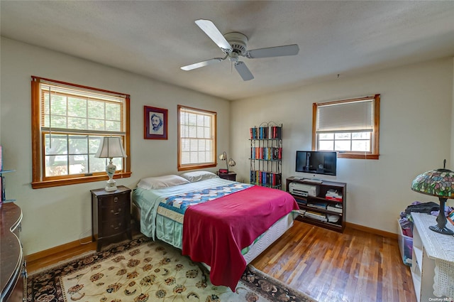 bedroom featuring multiple windows, ceiling fan, a textured ceiling, and hardwood / wood-style flooring