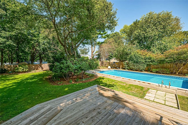 view of pool featuring a lawn and a wooden deck