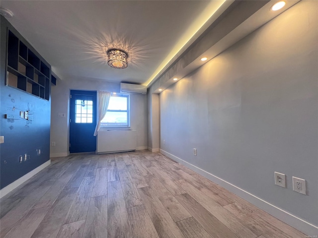 empty room with a wall mounted AC and wood-type flooring