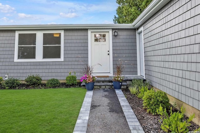 entrance to property featuring a lawn