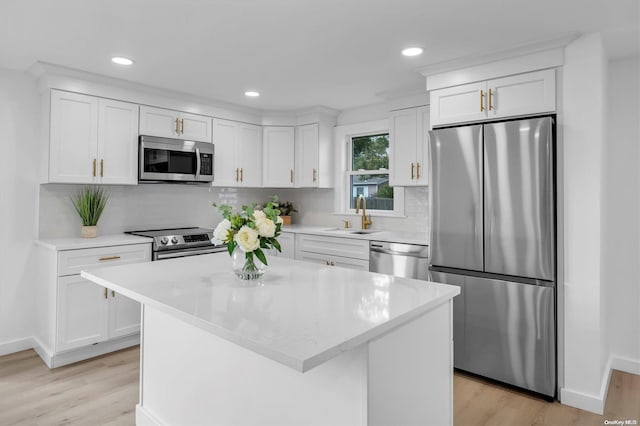 kitchen with white cabinets, stainless steel appliances, and a kitchen island