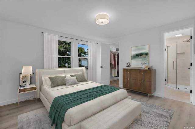 bedroom with a walk in closet, a closet, and hardwood / wood-style floors