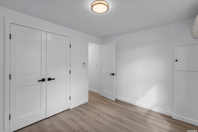 unfurnished bedroom with a closet and light hardwood / wood-style flooring