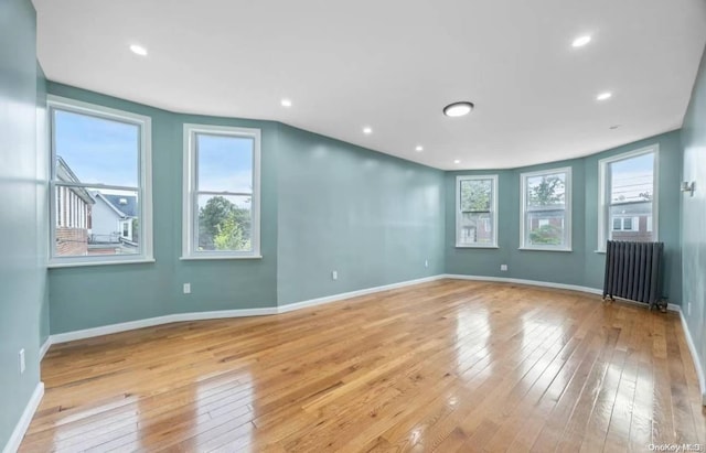 unfurnished room featuring light wood-type flooring and radiator