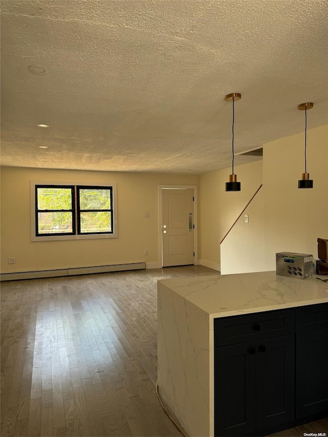 kitchen featuring pendant lighting, light hardwood / wood-style flooring, light stone countertops, a textured ceiling, and a baseboard radiator