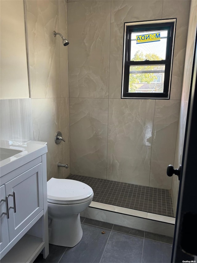 bathroom featuring tile patterned floors, vanity, toilet, and tile walls