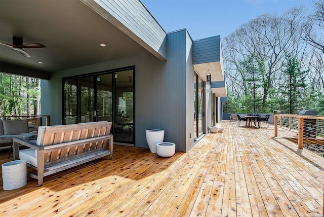 deck featuring ceiling fan and an outdoor living space