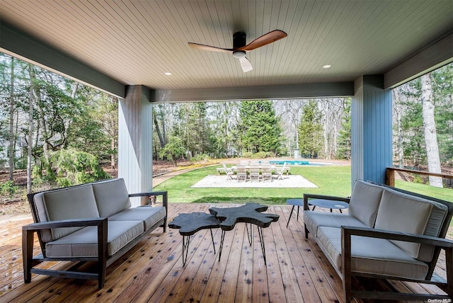 deck featuring outdoor lounge area, ceiling fan, a patio area, and a lawn