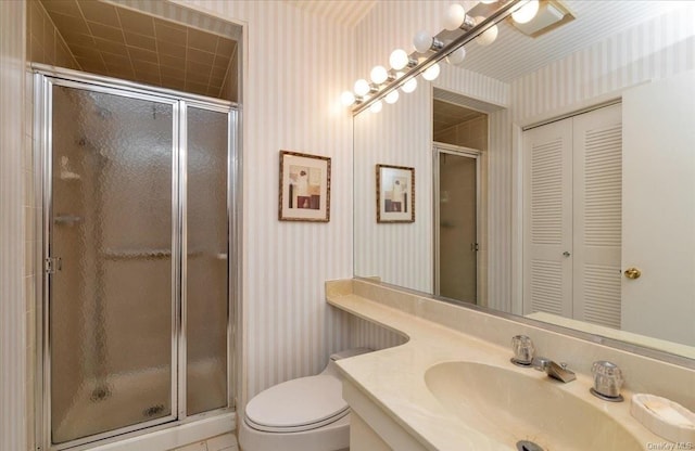 bathroom featuring tile patterned flooring, vanity, an enclosed shower, and toilet