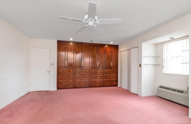 unfurnished bedroom with ceiling fan, light carpet, and a wall mounted AC