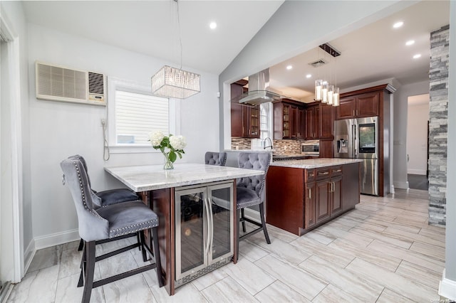 kitchen with pendant lighting, island range hood, kitchen peninsula, stainless steel appliances, and beverage cooler