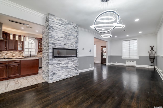 26-44 211th St, Bayside, NY 11360 - unfurnished living room featuring radiator heating unit, ornamental molding, a chandelier, wood finished floors, and a sink