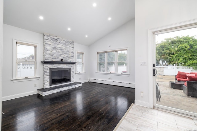 living room featuring a stone fireplace, light hardwood / wood-style flooring, high vaulted ceiling, and a baseboard radiator