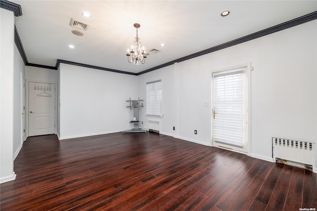 unfurnished room with dark hardwood / wood-style floors, radiator heating unit, crown molding, and an inviting chandelier