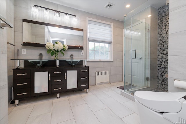 26-44 211th St, Bayside, NY 11360 - full bathroom with radiator, a stall shower, double vanity, tile walls, and tile patterned flooring