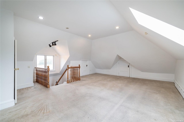 bonus room featuring vaulted ceiling with skylight and light colored carpet