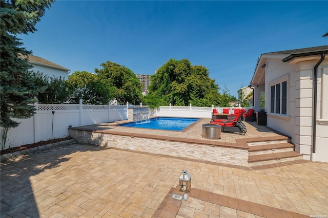 view of swimming pool featuring pool water feature and a patio area