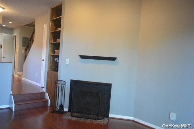 interior space featuring a textured ceiling and dark wood-type flooring