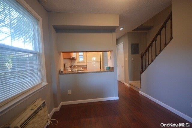 spare room featuring plenty of natural light, dark hardwood / wood-style floors, and a textured ceiling