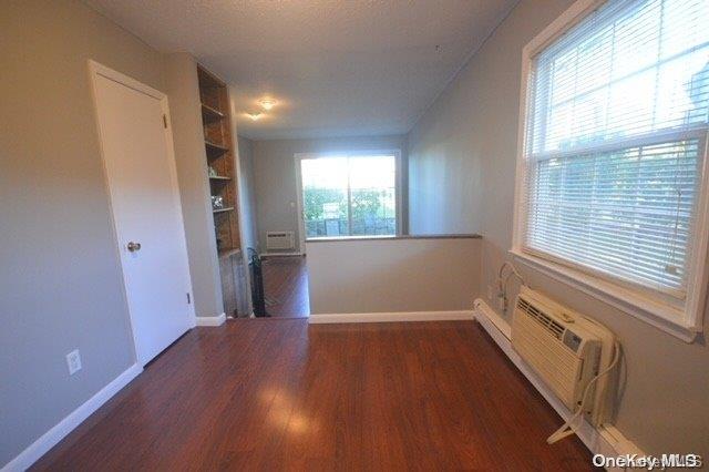 spare room featuring dark hardwood / wood-style flooring and built in features